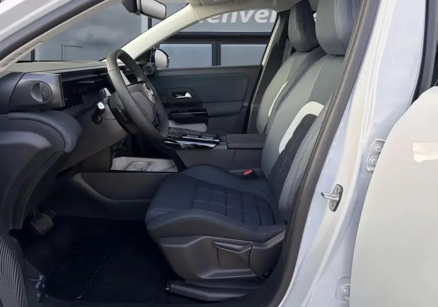 Vue intérieure côté conducteur du Citroën C5 Aircross blanc, montrant sièges tissu bleu et tableau de bord moderne.