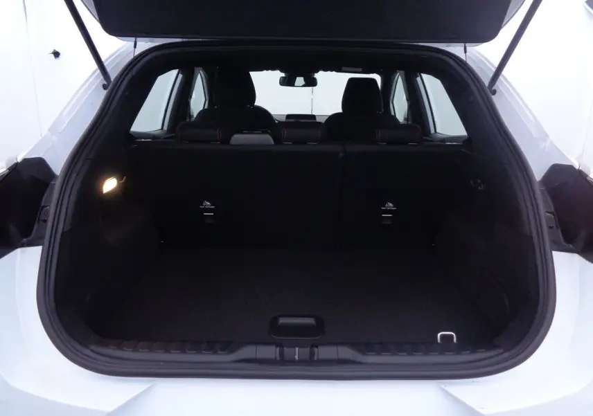Coffre ouvert d'un Ford Puma blanc 2022, vue arrière mettant en valeur l'espace de chargement et les sièges noirs.