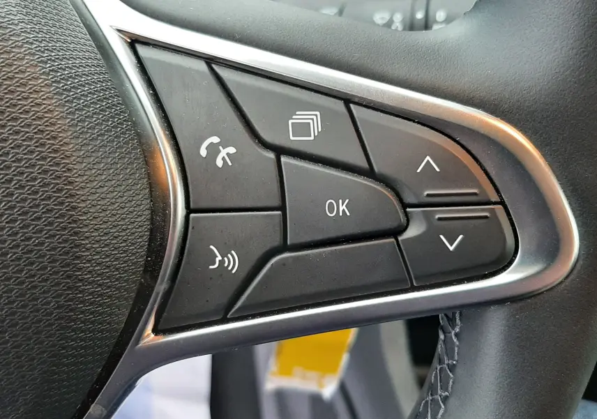 Gros plan sur les commandes multifonctions à droite du volant en cuir noir de la Renault Clio V gris schiste, version TCE 90CH EVOLUTION.