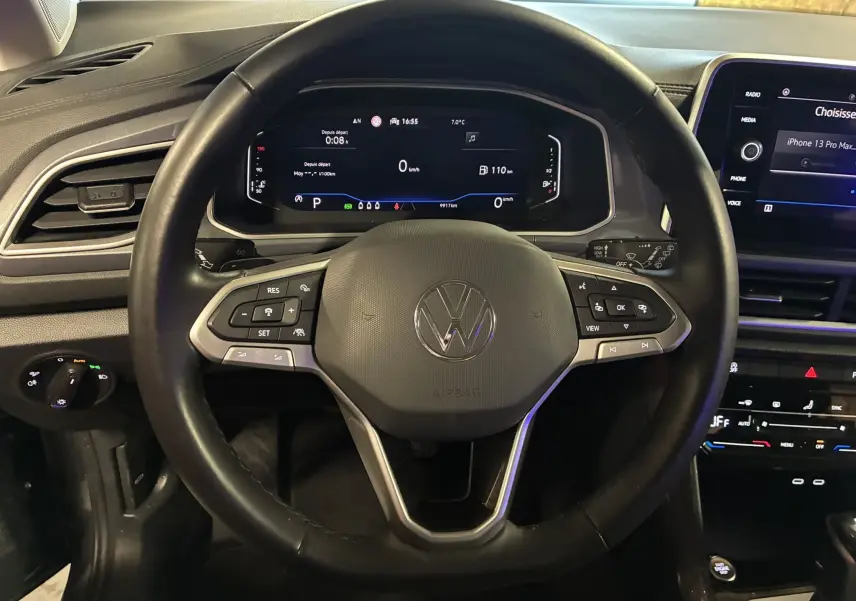 Vue frontale du volant noir du Volkswagen T-Roc 2023 avec tableau de bord numérique et écran tactile central.