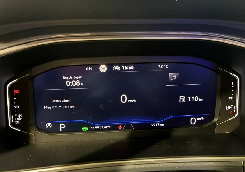 Vue rapprochée du tableau de bord numérique du Volkswagen T-Roc gris 2023, affichant la vitesse à 0 km/h et l'autonomie à 110 km.