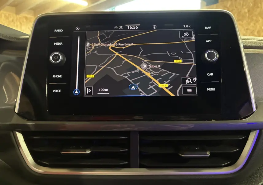 Écran tactile central du Volkswagen T-Roc gris 2023 montrant la navigation GPS avec commandes autour et aérateurs en dessous.