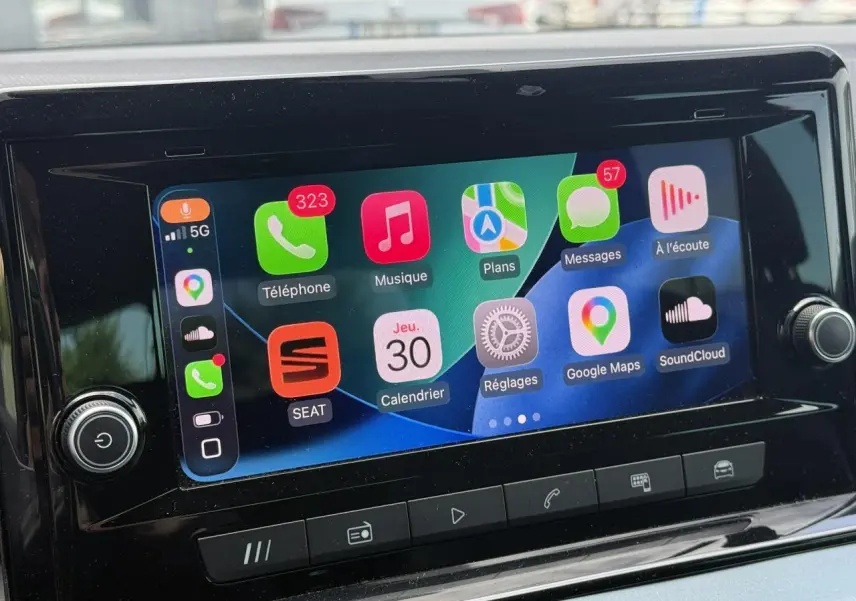 Écran tactile central affichant Apple CarPlay dans l'habitacle d'une SEAT Arona Gris Cliff, vue de face.