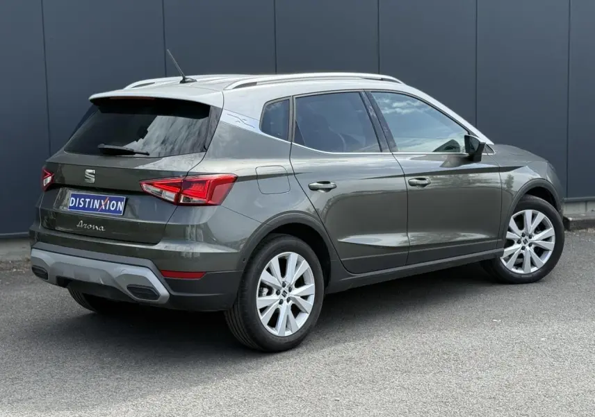 Vue 3/4 arrière droite d'un SEAT Arona gris Cliff avec toit blanc et jantes alliage 17 pouces.