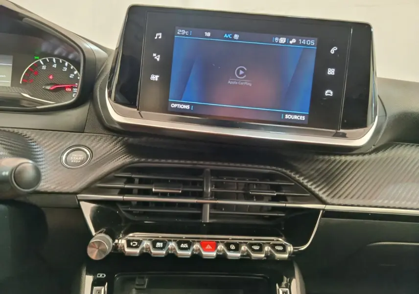 Vue rapprochée du tableau de bord du Peugeot 2008 bleu 2021, avec écran tactile Apple CarPlay et commandes en ligne.