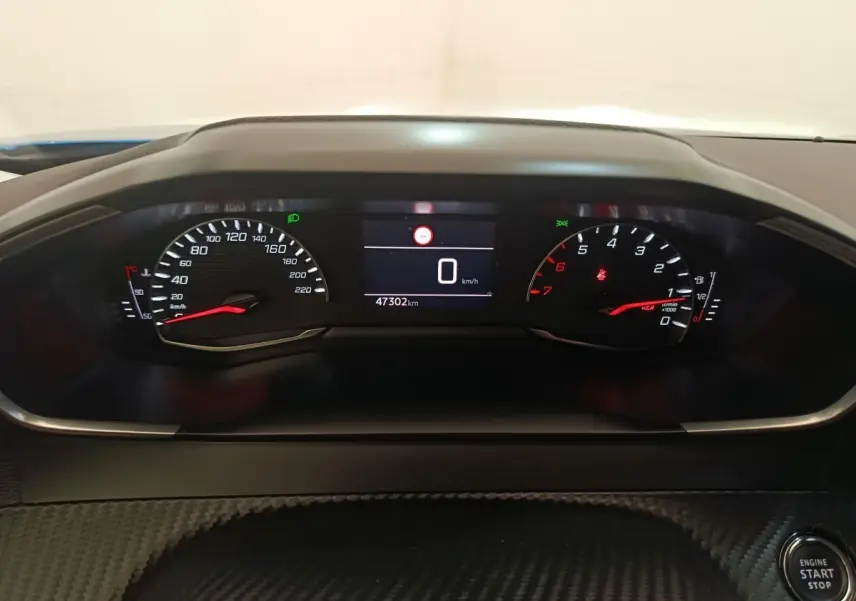 Vue rapprochée du tableau de bord de la Peugeot 2008 bleu, affichant le compteur et le bouton démarrage.