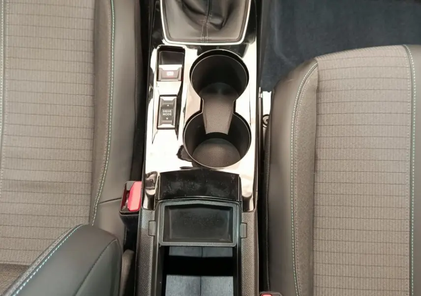 Vue plongeante sur la console centrale noire et la boîte manuelle entre les sièges gris à surpiqûres bleues du Peugeot 2008.