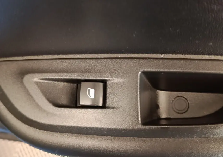Gros plan sur le bouton de commande électrique de la vitre côté conducteur d’une Peugeot 2008 bleu 2021.
