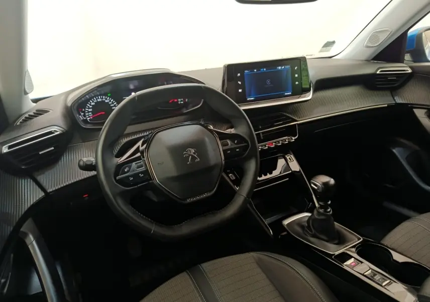 Vue intérieure avant du Peugeot 2008 bleu 2021, volant cuir multifonctions et écran tactile central visible.