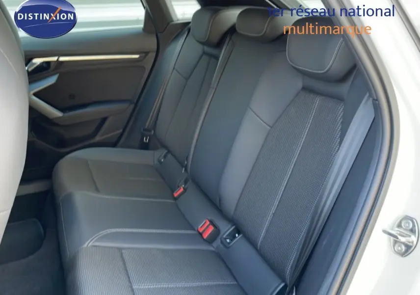 Vue intérieure côté droit des sièges arrière en tissu gris et cuir dans une Audi A3 Sportback blanc Ibis 2025.