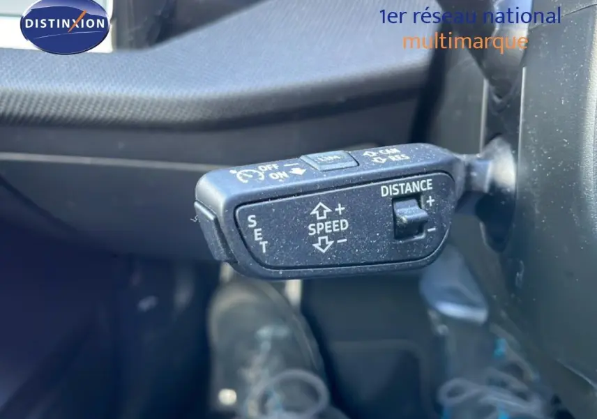 Gros plan sur la commande de régulateur de vitesse au volant d’une Audi A3 Sportback blanc Ibis 2025.