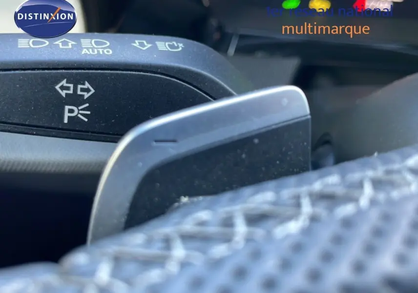 Gros plan sur la palette de changement de vitesse et le commodo des clignotants dans l'habitacle d'un Audi A3 Sportback blanc ibis.