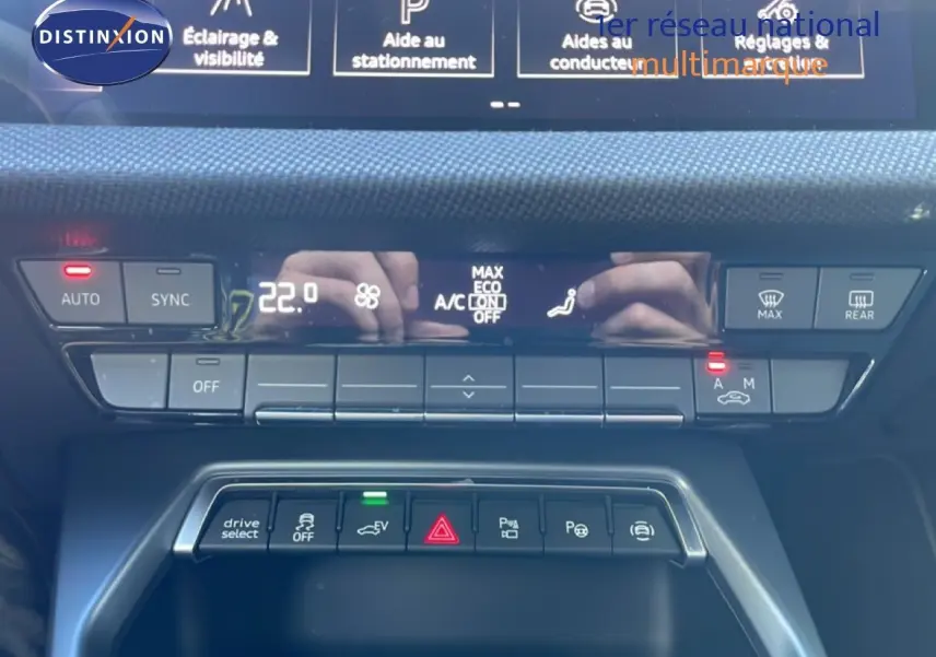 Vue rapprochée du tableau de bord de l'Audi A3 Sportback blanc Ibis 2025, mettant en valeur les commandes climatisation et aides à la conduite.