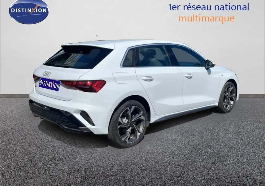 Audi A3 Sportback blanc Ibis vue 3/4 arrière droit, roues alliage noires et vitres teintées.