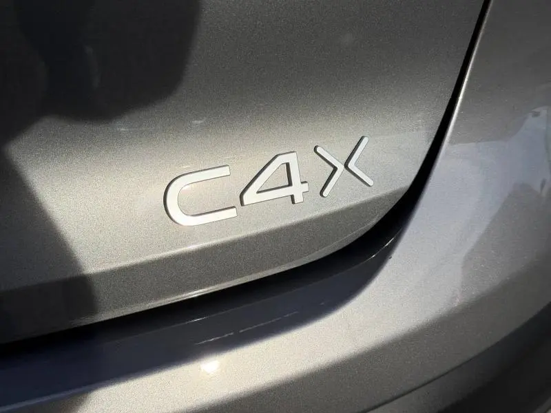 Gros plan sur l’inscription C4 X en relief sur la carrosserie gris Mercury d’un Citroën 2025.