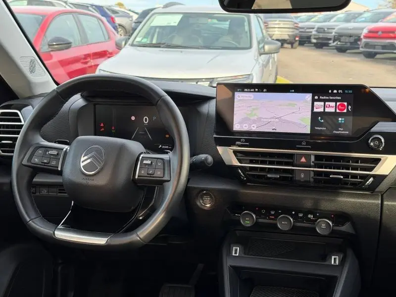 Vue intérieure du tableau de bord et volant de la Citroën C4 X 2025, avec écran tactile et commandes au volant visibles.