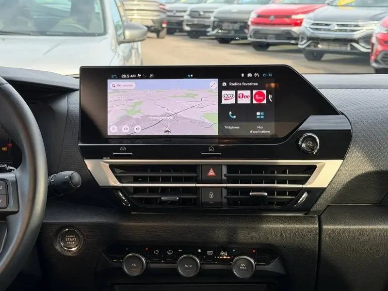 Vue intérieure du tableau de bord du Citroën C4 X 2025, écran tactile central avec navigation et commandes climatisation visibles.