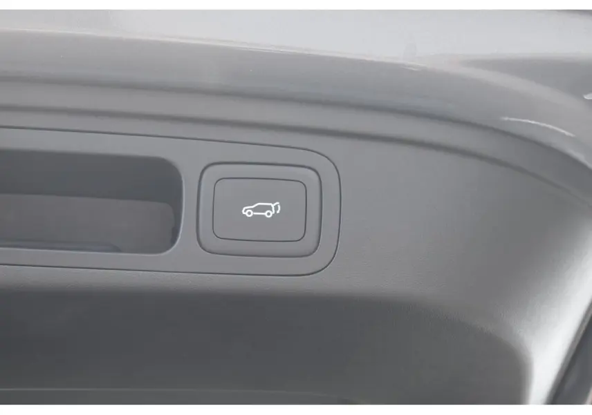 Bouton d'ouverture électrique du coffre sur le panneau intérieur d'un MG Motor EHS gris hybride 2026.