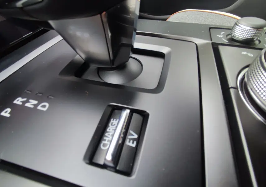 Gros plan sur la commande de boîte automatique et les boutons Charge et EV du Mazda MX-30 gris foncé hybride rechargeable 2023.