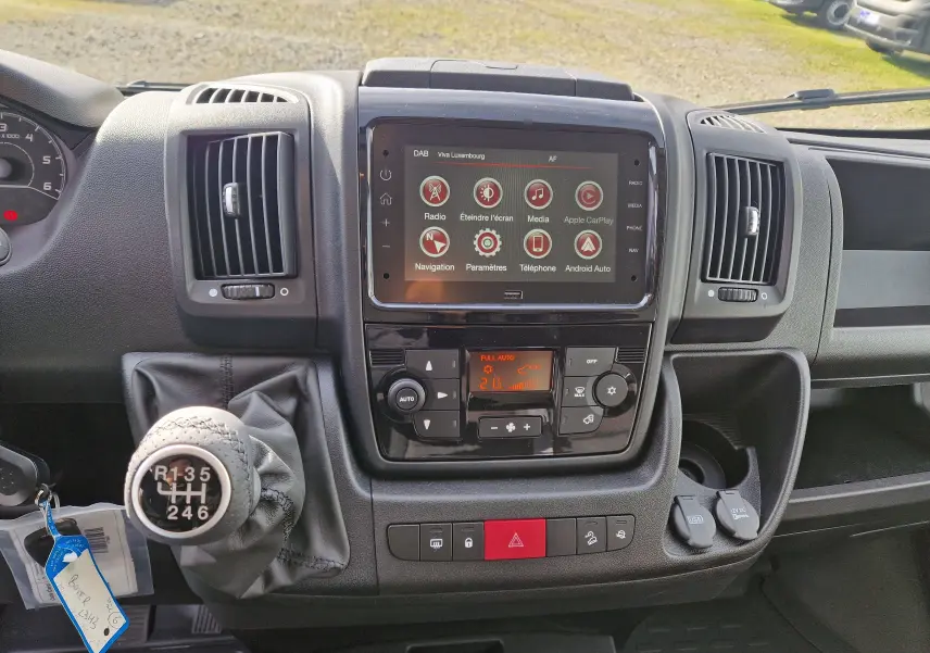 Tableau de bord du Citroën Jumper blanc 2023, vue frontale centrée sur la console avec écran tactile et levier de vitesses manuel.