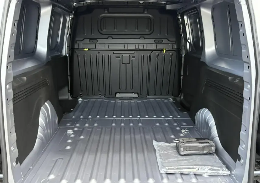 Vue intérieure de la zone de chargement grise Artense du Citroën Berlingo Van XL 2025, avec rangement et trappe visible.