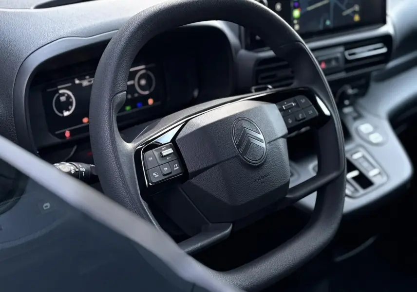 Volant multifonctions noir vu de près dans l'habitacle du Citroën Berlingo Van XL 2025 avec tableau de bord numérique.