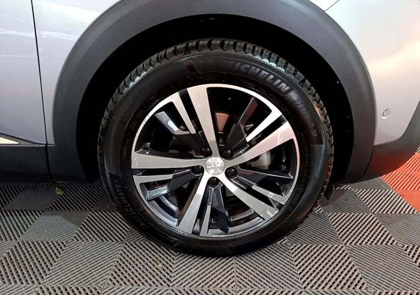 Gros plan sur la roue avant droite gris clair du Peugeot 5008 avec jante alliage noir et argentée et pneu Michelin.