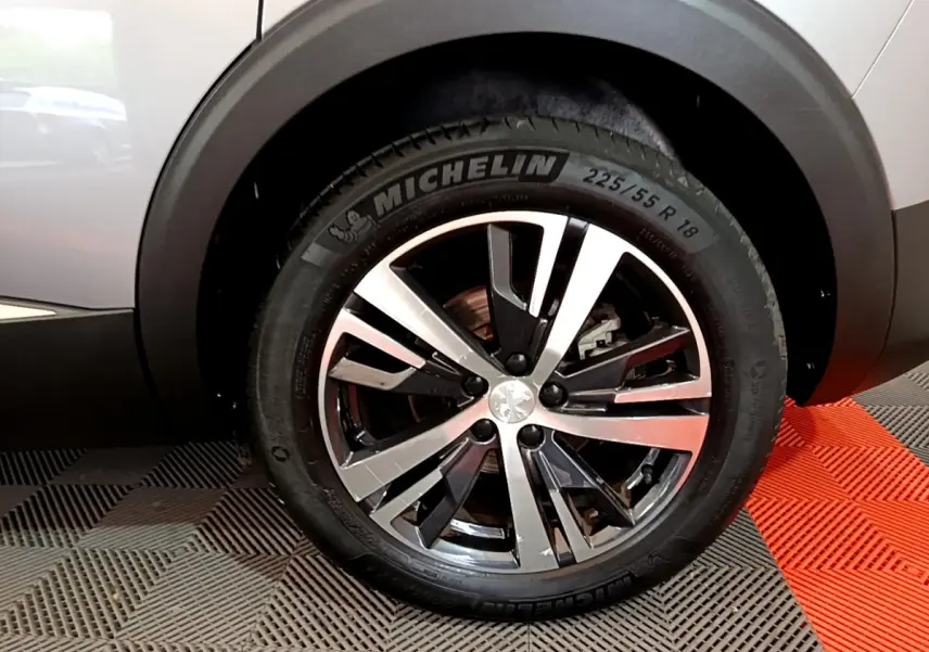 Gros plan sur la roue avant droite du Peugeot 5008 gris clair, jante alliage et pneu Michelin visible.