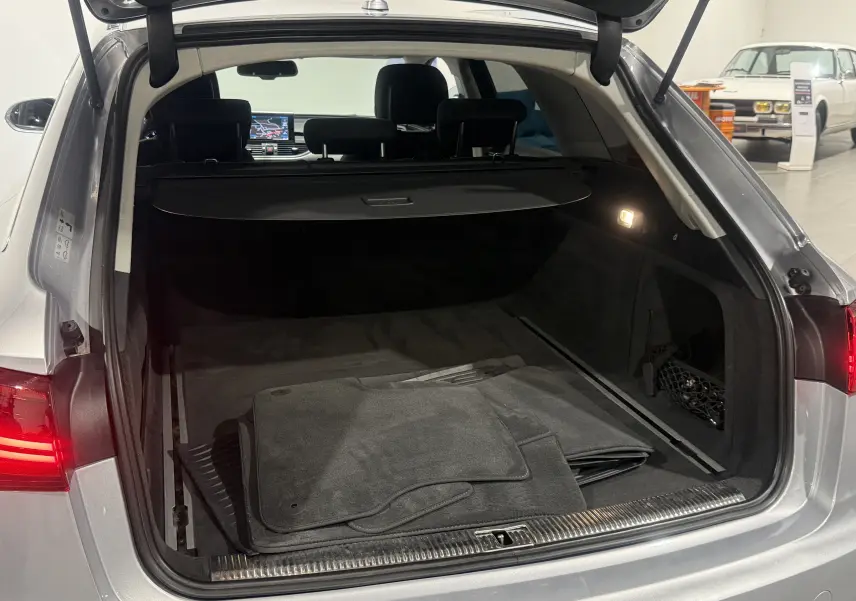 Coffre ouvert d'une Audi A6 Avant gris 3.0 TDI 2015, vue arrière montrant l'espace de chargement et tapis de sol.