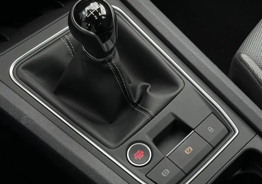 Gros plan sur levier de vitesse manuel noir et bouton start/stop rouge dans l’habitacle d’une SEAT Leon 2025.