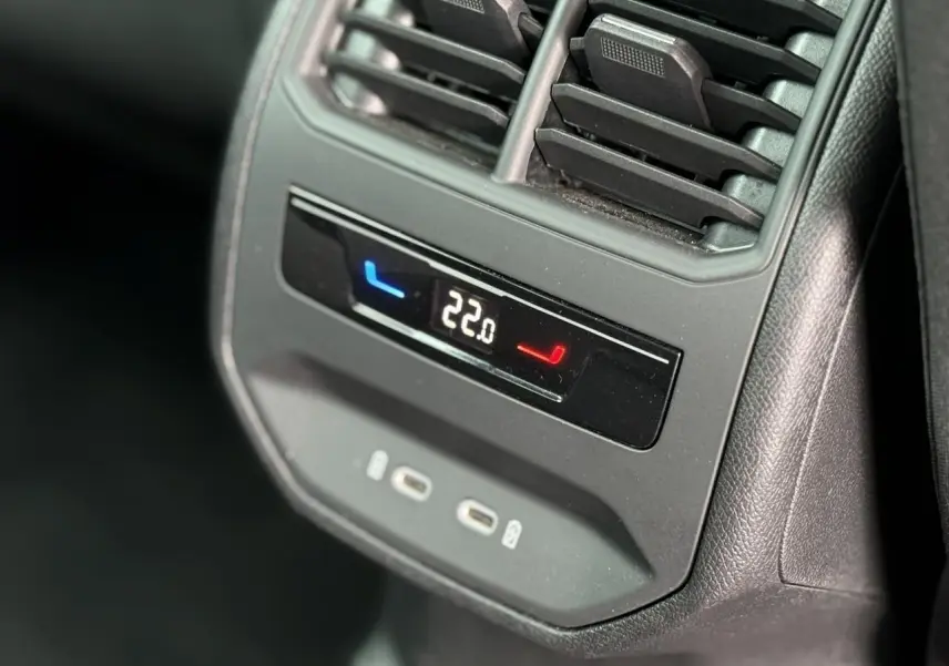 Détail du panneau de climatisation arrière avec affichage digital et ports USB-C dans une SEAT Leon noir Minuit.