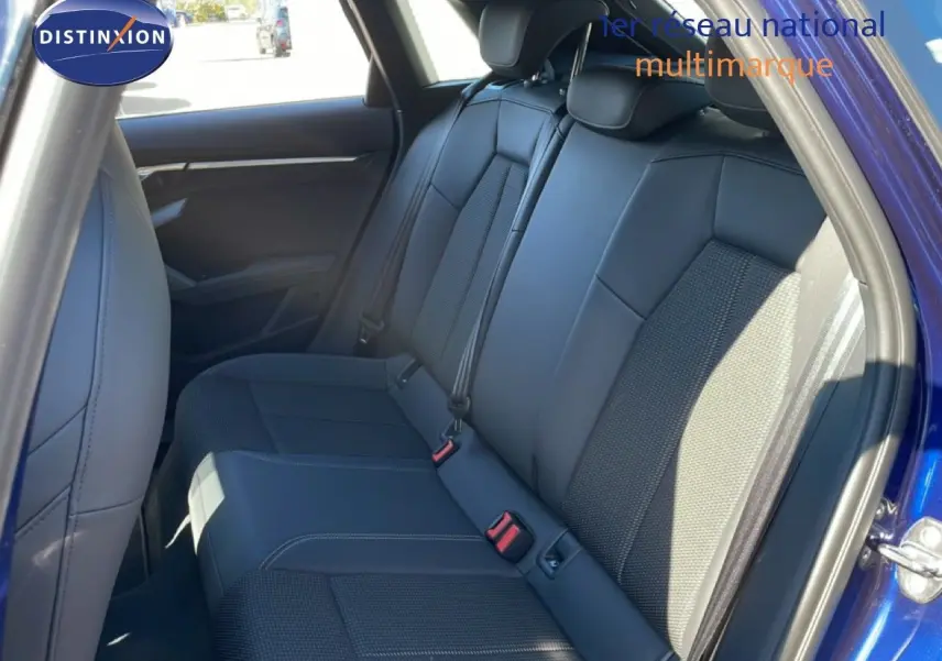 Vue intérieure côté arrière droit montrant les sièges arrière en tissu gris foncé d'une Audi A3 Sportback Bleu Navarre 2025.