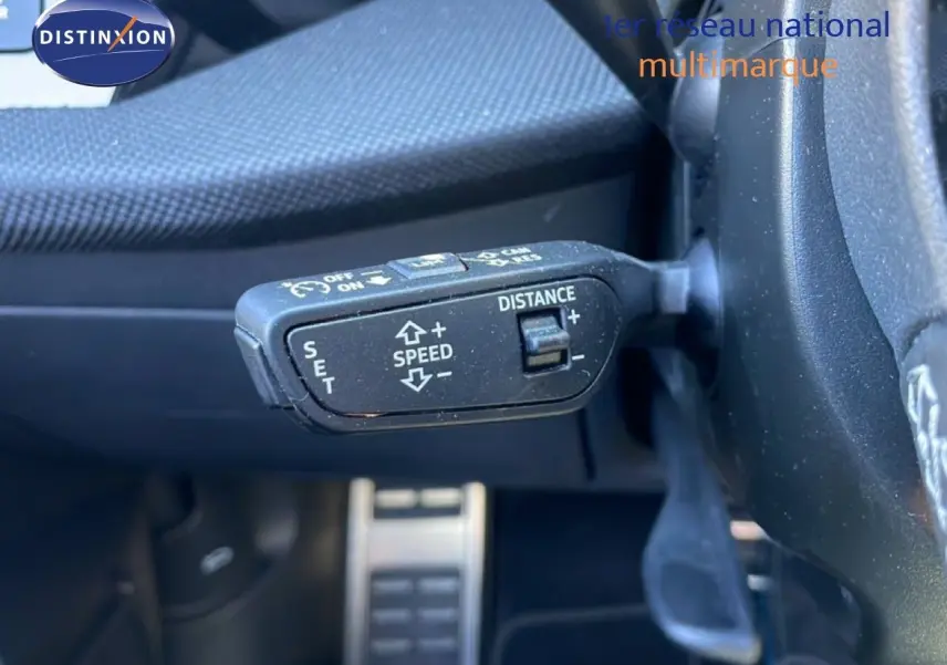 Gros plan sur la commande de régulateur de vitesse au volant d’un Audi A3 Sportback bleu Navarre 2025.
