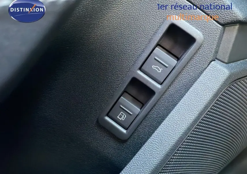 Gros plan sur les boutons d'ouverture du coffre et de la trappe à carburant dans l'habitacle noir de l'Audi A3 Sportback 2025.