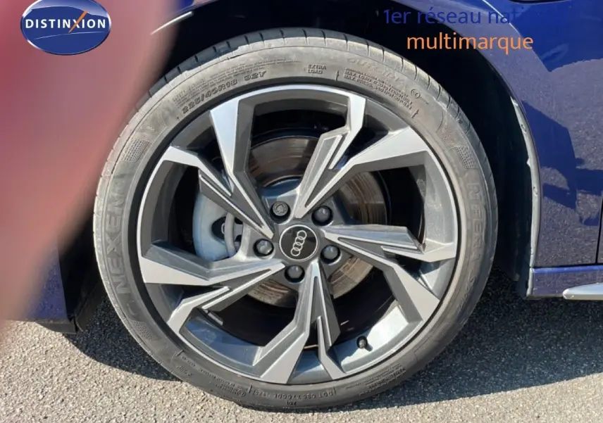 Gros plan sur la roue avant droite d'une Audi A3 Sportback bleu Navarre métal, avec jante alliage au design moderne.