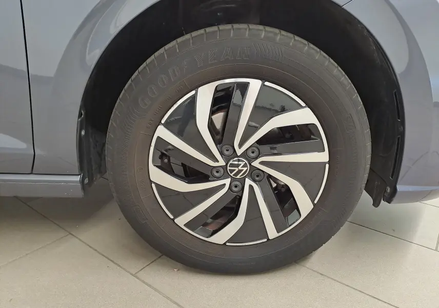 Gros plan sur la roue avant gauche d'une Volkswagen Polo gris cendre avec jante alliage bicolore moderne.