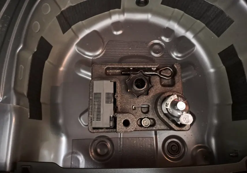 Coffre à outils de secours dans le compartiment de roue de secours d'une Volkswagen Polo gris cendre 2025.