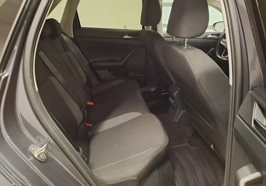 Vue intérieure côté gauche des sièges arrière en tissu noir d'une Volkswagen Polo gris cendre 2025, version VW Edition.