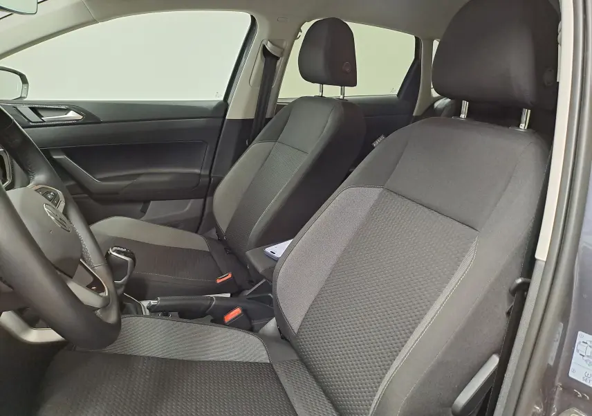 Vue intérieure côté gauche montrant les sièges avant noirs et la porte d'une Volkswagen Polo gris cendre 2025.