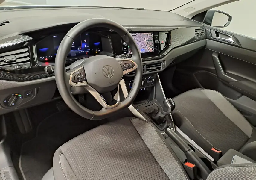 Vue intérieure côté conducteur de la Volkswagen Polo 2025, tableau de bord moderne avec écran tactile et volant multifonction noir.