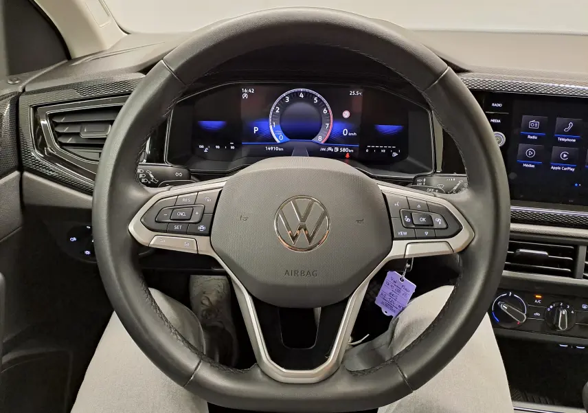 Vue centrée sur le volant noir du Volkswagen Polo 2025 avec tableau de bord numérique et écran tactile à droite.