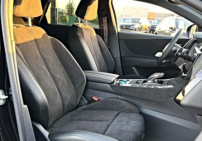 Intérieur avant du DS7 1.5 BlueHDi noir, vue côté gauche montrant sièges en cuir et alcantara avec surpiqûres décoratives.