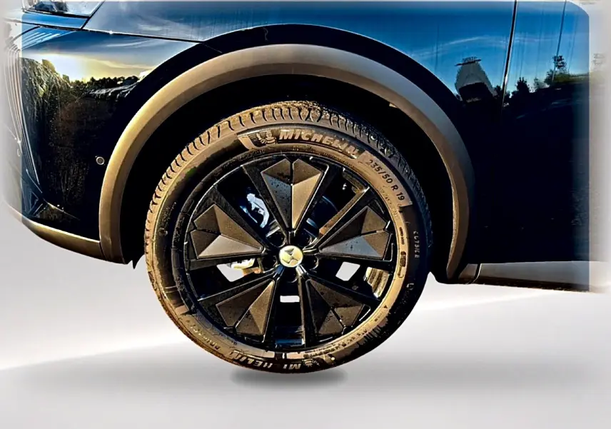 Gros plan sur la roue avant droite noire d'un DS7 1.5 BlueHDi 130 avec jante alu au design géométrique.