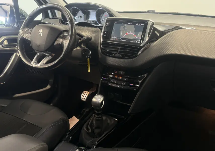 Intérieur du Peugeot 2008 2018, vue côté conducteur, volant compact, écran tactile et levier de vitesse manuel visibles.