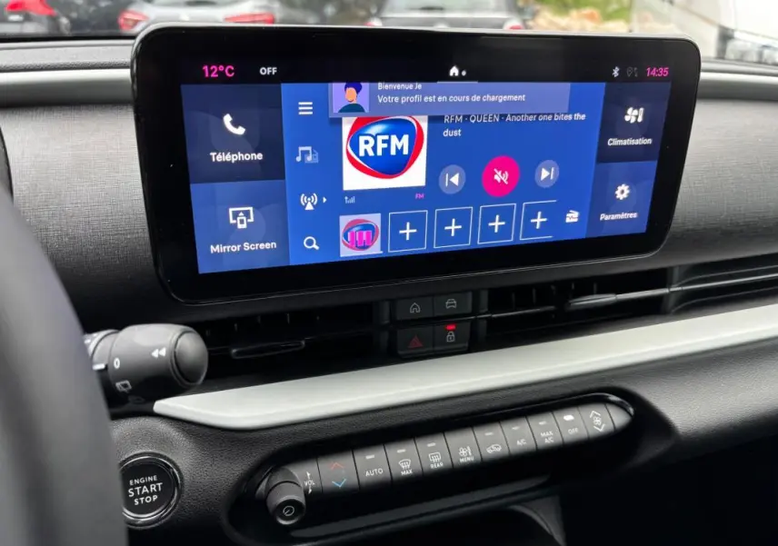 Vue rapprochée de l’écran tactile central et des commandes de climatisation du tableau de bord de la Fiat 600 blanche 2024.