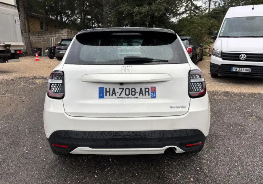 Vue arrière d'une FIAT 600 blanche 2024 avec feux arrière à motifs LED et logo hybride visible.