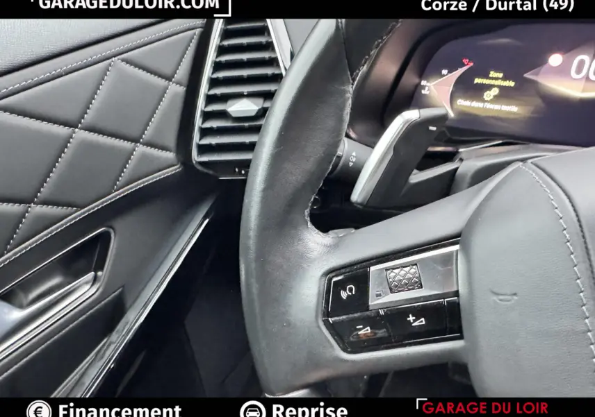 Gros plan sur le volant en cuir noir et partie gauche du tableau de bord matelassé du DS7 Crossback bleu 2024.