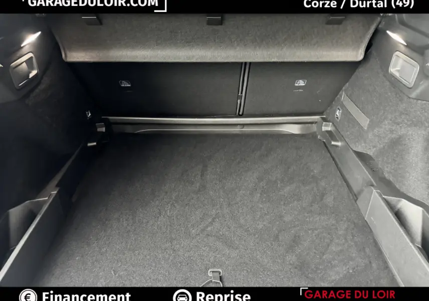 Coffre spacieux du DS7 Crossback bleu, vue intérieure arrière avec revêtement noir et rangements latéraux.