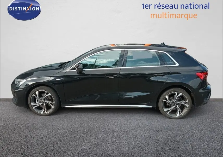 Profil droit d'une Audi A3 Sportback noire Mito Metal 2025 avec jantes alliage et finition S-Line visible.