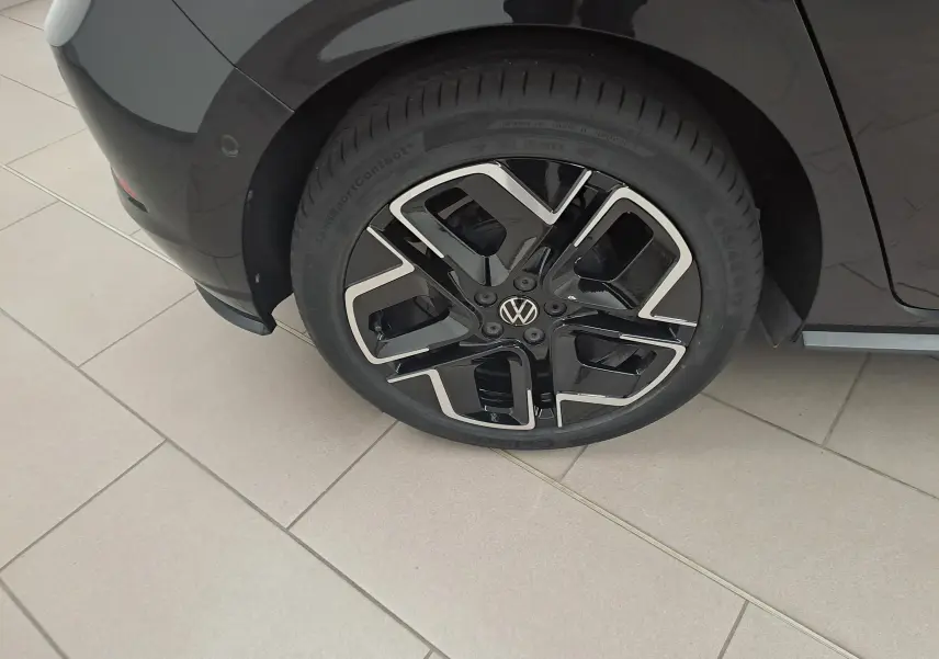 Gros plan sur la roue arrière gauche d'une Volkswagen Polo 2025 Noir Intense avec jante alliage R-Line noire et argent.